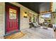 Charming covered porch with comfortable seating, brick accents, and a red front door at 562 N Gilpin St, Denver, CO 80218
