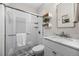 Modern bathroom features a glass enclosed shower, marble floors, and floating shelves at 3321 Navajo St, Denver, CO 80211