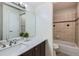 Well-lit bathroom features a marble vanity, large mirror, and a bathtub with tile surround at 3550 S Harlan St # 177, Denver, CO 80235