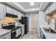 Well-lit kitchen with modern gray cabinets, skylight, black appliances and light countertops, creating a functional cooking space at 3550 S Harlan St # 177, Denver, CO 80235