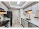 Bright kitchen featuring stainless steel appliances, gray cabinets, and access to an adjacent laundry area at 3550 S Harlan St # 177, Denver, CO 80235