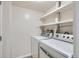 Laundry room with white washer and dryer and shelving for optimal organization at 3550 S Harlan St # 177, Denver, CO 80235