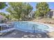 Outdoor community pool with lounge chairs, tables and fenced surround at 3550 S Harlan St # 177, Denver, CO 80235