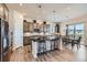 Modern kitchen features a large island with seating, stainless steel appliances, and elegant pendant lighting over the dining space at 4536 Shady Path Ln, Castle Rock, CO 80104