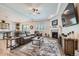 Open-concept living room with a fireplace, large-screen TV, tray ceiling, and comfortable seating adjacent to the kitchen at 4536 Shady Path Ln, Castle Rock, CO 80104
