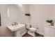 Elegant powder room with pedestal sink, toilet, and stylish decor, offering a convenient space for guests at 4536 Shady Path Ln, Castle Rock, CO 80104