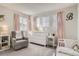 Charming Bedroom with pink accents, glider, white furniture, and cozy decor at 6550 S Oak Ct, Littleton, CO 80127