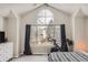 Cozy bedroom featuring a large arched window, exercise bike, comfortable carpet, and modern furnishings at 6550 S Oak Ct, Littleton, CO 80127