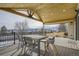 Inviting covered deck with mountain views, wooden ceiling beams, and stylish outdoor dining furniture at 6550 S Oak Ct, Littleton, CO 80127