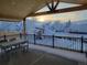 Covered deck with a wintery view, a picnic table, and wrought iron fencing at 6550 S Oak Ct, Littleton, CO 80127