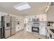 Bright kitchen featuring white cabinets, stainless appliances, and a subway tile backsplash, creating a clean aesthetic at 6550 S Oak Ct, Littleton, CO 80127