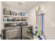 Well-organized laundry room with modern washer and dryer, shelving, and cleaning supplies at 6550 S Oak Ct, Littleton, CO 80127