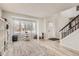 Bright living area features wood floors, a large window, and a modern staircase, creating a welcoming space at 6550 S Oak Ct, Littleton, CO 80127