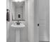 Well-lit bathroom featuring a pedestal sink, a mirror, and a door leading to another room at 4418 Soapberry Pl, Castle Rock, CO 80108