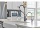 Kitchen island featuring a sink, black faucet, and black backsplash at 4418 Soapberry Pl, Castle Rock, CO 80108