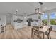Bright, open-concept kitchen and dining area featuring white cabinets, stainless steel appliances, and modern fixtures at 4418 Soapberry Pl, Castle Rock, CO 80108