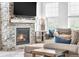 Cozy living room with a stone fireplace, comfortable seating, and ample natural light at 4418 Soapberry Pl, Castle Rock, CO 80108