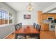 Bright dining room featuring a wood table, stylish lighting, and adjacent kitchen area at 770 S Youngfield, Lakewood, CO 80228