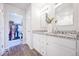 Elegant bathroom with dual vanity, granite countertops, and a view into a spacious walk-in closet at 5354 Blue Lunar Ln, Castle Rock, CO 80104