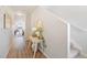 Inviting hallway with light wood flooring, decorative table, and staircase access at 5354 Blue Lunar Ln, Castle Rock, CO 80104