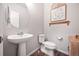Cozy powder room features pedestal sink, modern fixtures, decorative mirror and a quaint water closet at 5354 Blue Lunar Ln, Castle Rock, CO 80104