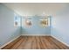 Sunlit bedroom showcasing wood floors, blue walls, and natural light streaming through multiple windows at 913 Alkire Ct, Golden, CO 80401