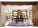 Bright dining area features hardwood floors, brick accent wall, stylish lighting, and access to the outdoor balcony at 913 Alkire Ct, Golden, CO 80401