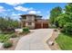 Charming two-story home showcasing manicured landscaping, a curved driveway, and a three-car garage at 913 Alkire Ct, Golden, CO 80401