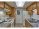 Efficient kitchen features wood cabinets, stainless steel sink, and electric range at 8600 E Alameda Ave # 17-203, Denver, CO 80247