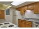 Functional kitchen features white appliances, wood cabinets, and ample counter space at 8600 E Alameda Ave # 17-203, Denver, CO 80247