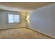 Bright living room featuring neutral carpet, a large window, and fresh light blue paint at 8600 E Alameda Ave # 17-203, Denver, CO 80247