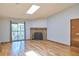 Comfortable living room with stone fireplace, wood floors, and sliding glass door at 8600 E Alameda Ave # 17-203, Denver, CO 80247