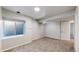 Basement showing window well, carpeted floor and access door at 1229 Berganot Trl, Castle Pines, CO 80108