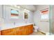 Bright bathroom with double vanity, framed mirrors, and a window for natural light at 1229 Berganot Trl, Castle Pines, CO 80108