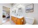 Bathroom featuring a double vanity, a toilet, and a view into the bedroom at 1229 Berganot Trl, Castle Pines, CO 80108