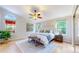Bright bedroom with a ceiling fan, white bed, and natural light from two windows at 1229 Berganot Trl, Castle Pines, CO 80108