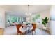 Bright dining room featuring a modern chandelier and large windows overlooking the backyard at 1229 Berganot Trl, Castle Pines, CO 80108