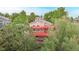 A multi-level home with a red deck and mature trees providing privacy at 1229 Berganot Trl, Castle Pines, CO 80108