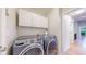 Laundry room with side-by-side washer and dryer, cabinets and a doorway at 1229 Berganot Trl, Castle Pines, CO 80108