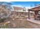 View of the backyard featuring a seating area, mature trees, and garden space at 11885 Helena St, Commerce City, CO 80022