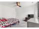 Bright bedroom featuring a bed with geometric patterned bedding, grey dresser, and a ceiling fan at 11885 Helena St, Commerce City, CO 80022