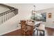Cozy dining room featuring hardwood floors, a farmhouse table, and a modern light fixture at 11885 Helena St, Commerce City, CO 80022