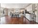 Bright kitchen features white cabinets, stainless steel appliances, kitchen island, and hardwood floors at 11885 Helena St, Commerce City, CO 80022