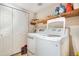 Well-lit laundry room featuring modern, front-load washer and dryer, plus storage shelves at 11885 Helena St, Commerce City, CO 80022