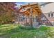Inviting backyard deck features a wood pergola, fan, and lush green lawn, perfect for outdoor living at 942 Xenon Ct, Golden, CO 80401