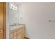 Bathroom vanity with drawers, granite countertop and a sink with decorative lighting above the mirror at 942 Xenon Ct, Golden, CO 80401