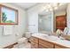 Bright bathroom featuring a vanity, toilet, mirror, and a window allowing natural light at 942 Xenon Ct, Golden, CO 80401
