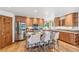 Well-equipped kitchen island featuring barstool seating, stainless steel appliances, and hardwood floors at 942 Xenon Ct, Golden, CO 80401
