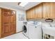 Functional laundry room with modern washer, dryer, utility sink, and ample cabinet storage at 942 Xenon Ct, Golden, CO 80401