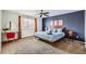 Well-lit main bedroom featuring a ceiling fan, blue accent wall, and modern decor at 7074 Yates St, Westminster, CO 80030